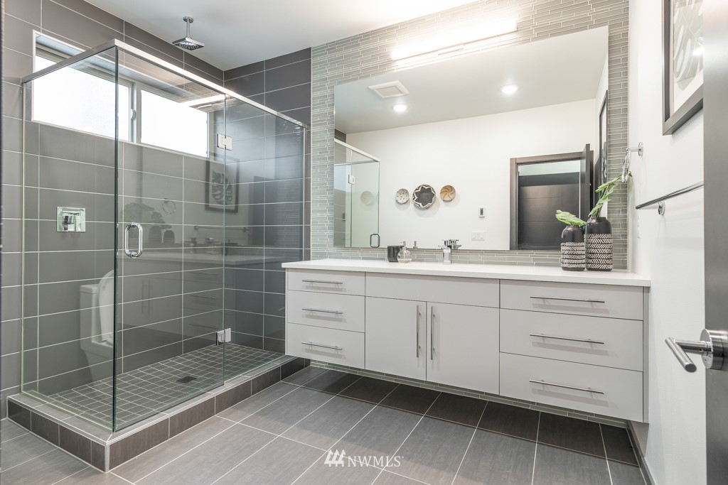 744 North 95th Street, Unit B Seattle, WA 98103 - Photo 15 of 28 a bathroom with a shower sink and mirror