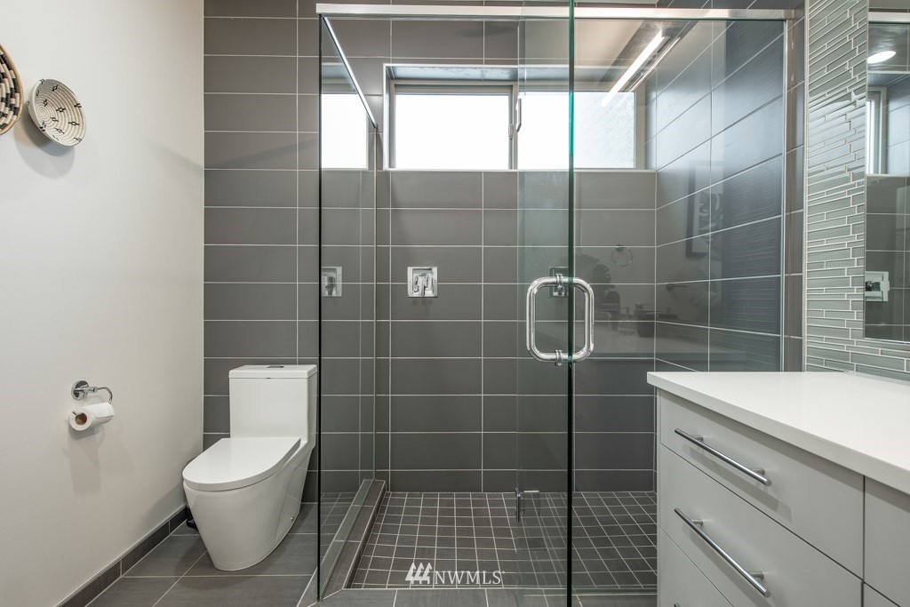 744 North 95th Street, Unit B Seattle, WA 98103 - Photo 16 of 28 a bathroom with a toilet a sink and a shower