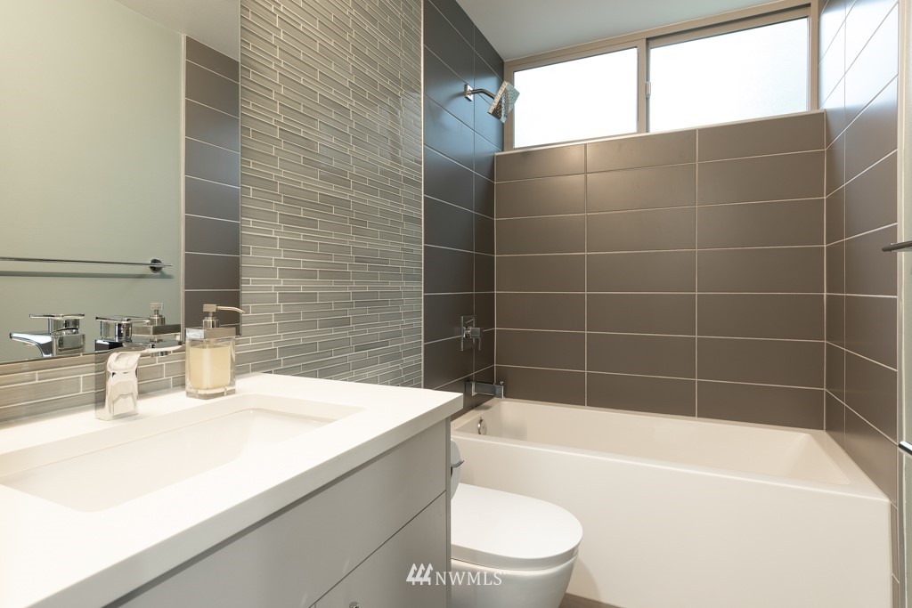 744 North 95th Street, Unit B Seattle, WA 98103 - Photo 25 of 28 a bathroom with a bathtub a sink a toilet and shower