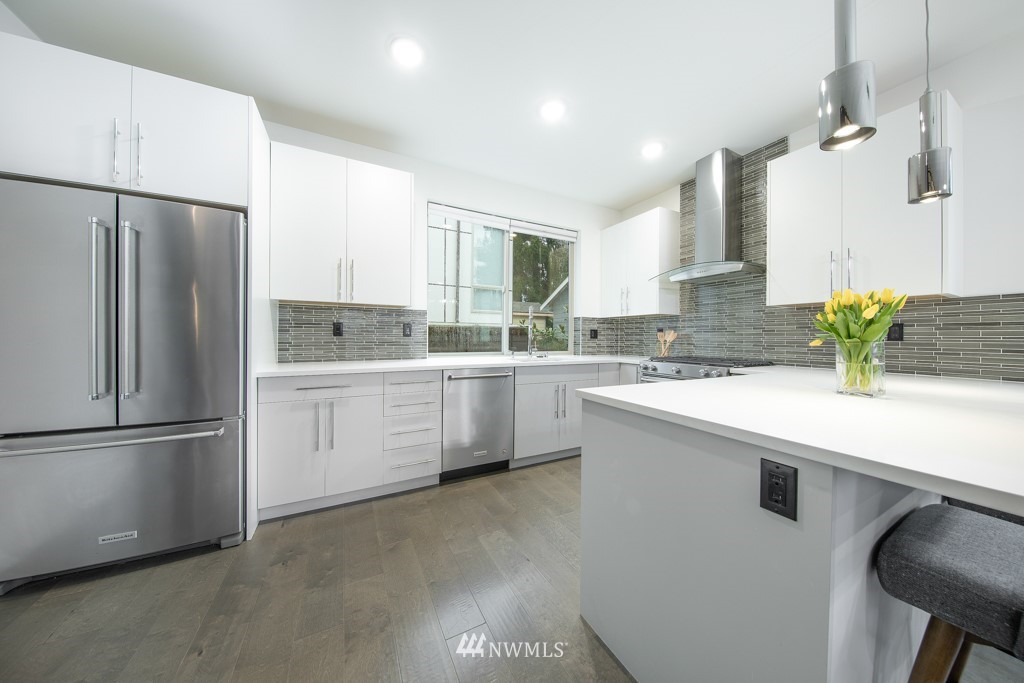 744 North 95th Street, Unit B Seattle, WA 98103 - Photo 3 of 28 a kitchen with a sink stainless steel appliances and cabinets