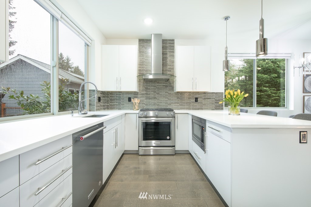 744 North 95th Street, Unit B Seattle, WA 98103 - Photo 4 of 28 a kitchen with stainless steel appliances cabinets a large window and a sink