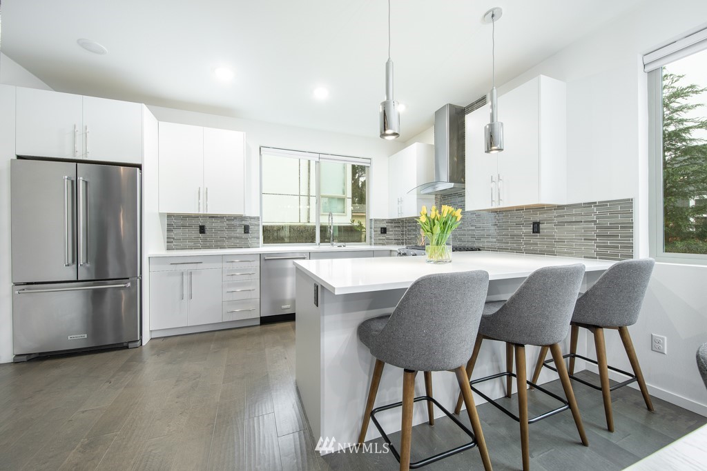 744 North 95th Street, Unit B Seattle, WA 98103 - Photo 5 of 28 a kitchen with a table chairs refrigerator a sink and cabinets