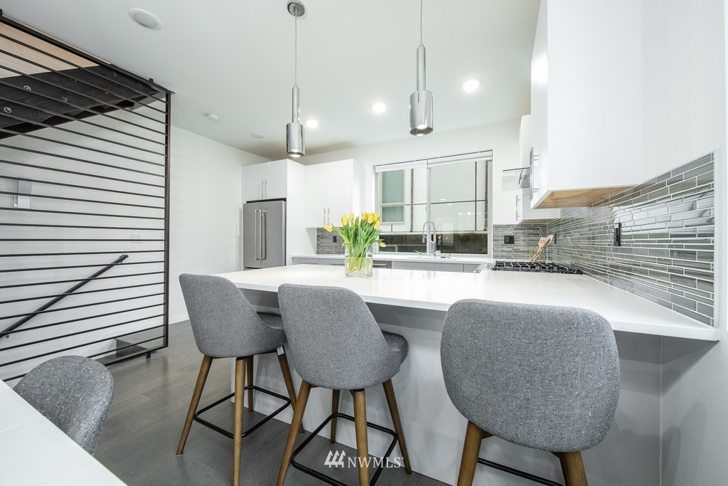 744 North 95th Street, Unit B Seattle, WA 98103 - Photo 6 of 28 a kitchen with a table chairs and wooden cabinets