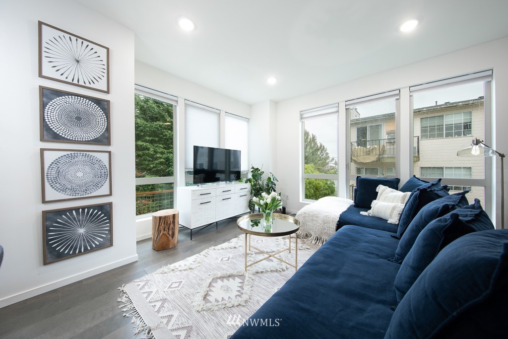 744 North 95th Street, Unit B Seattle, WA 98103 - Photo 8 of 28 a living room with furniture a flat screen tv and a floor to ceiling window