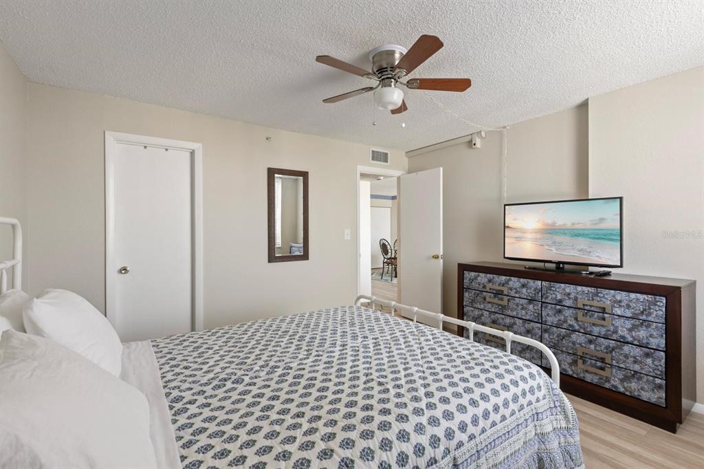 255 Dolphin Point, Unit 513 Clearwater Beach, FL 33767 - Photo 12 of 18 a bedroom with a bed and a flat screen tv