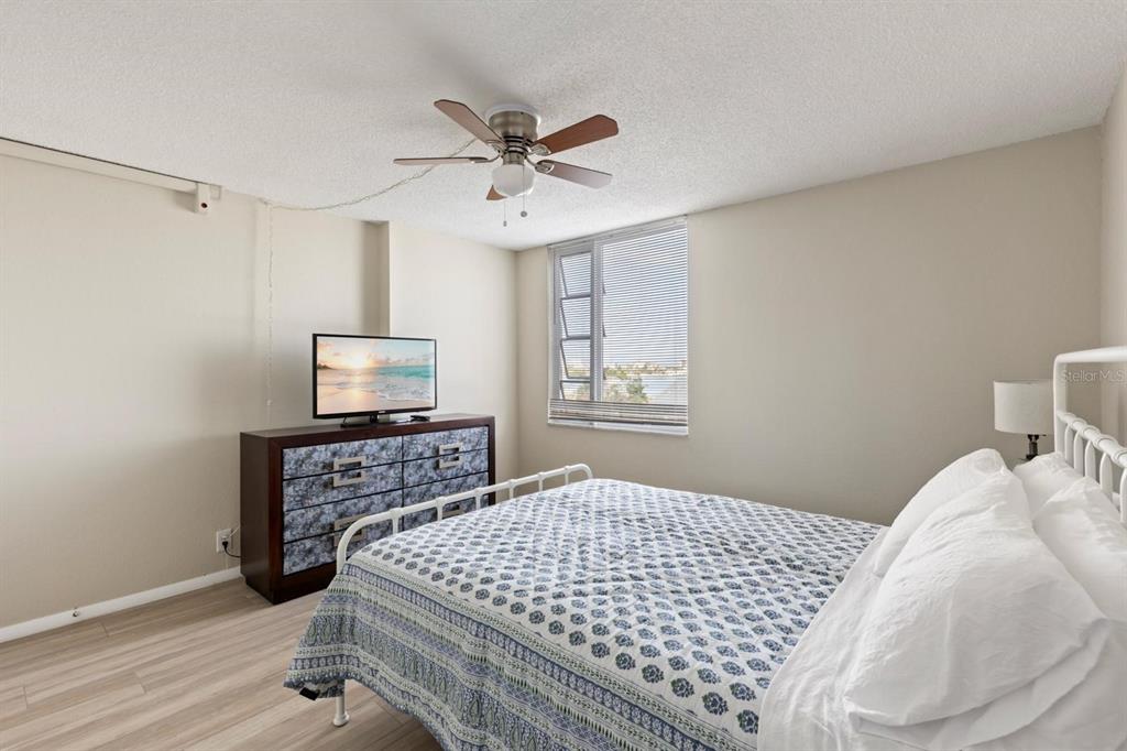 255 Dolphin Point, Unit 513 Clearwater Beach, FL 33767 - Photo 13 of 18 a bedroom with a bed and a tv