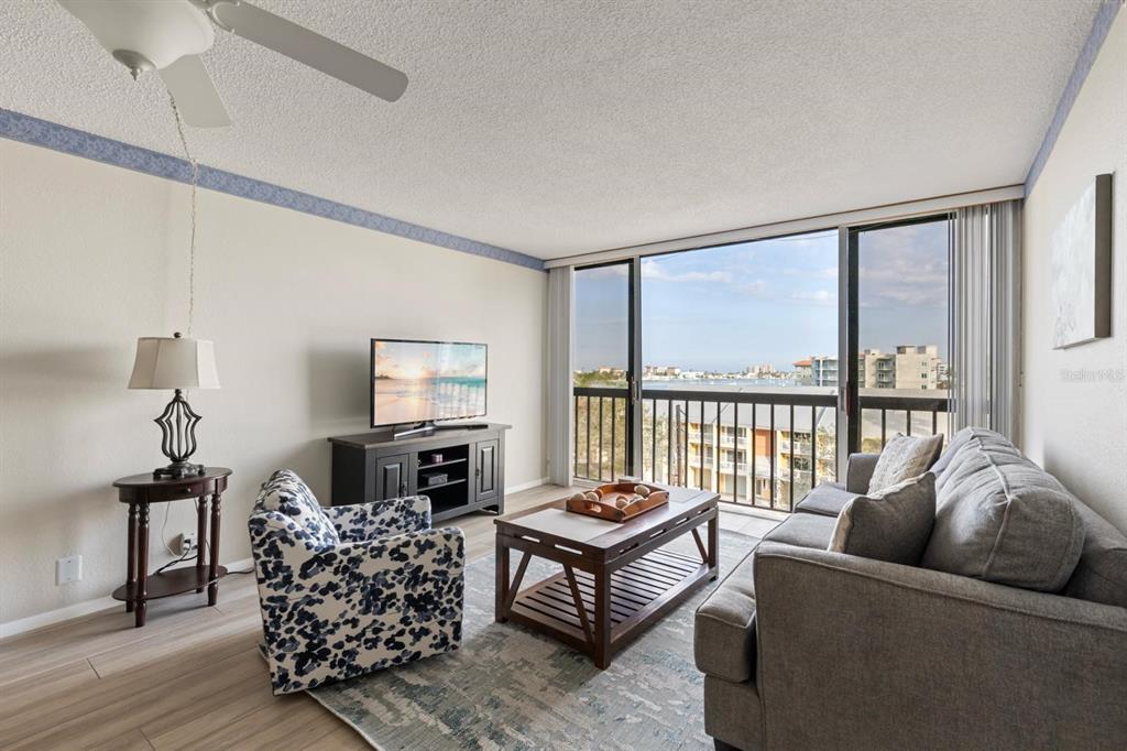 255 Dolphin Point, Unit 513 Clearwater Beach, FL 33767 - Photo 7 of 18 a living room with furniture and a floor to ceiling window