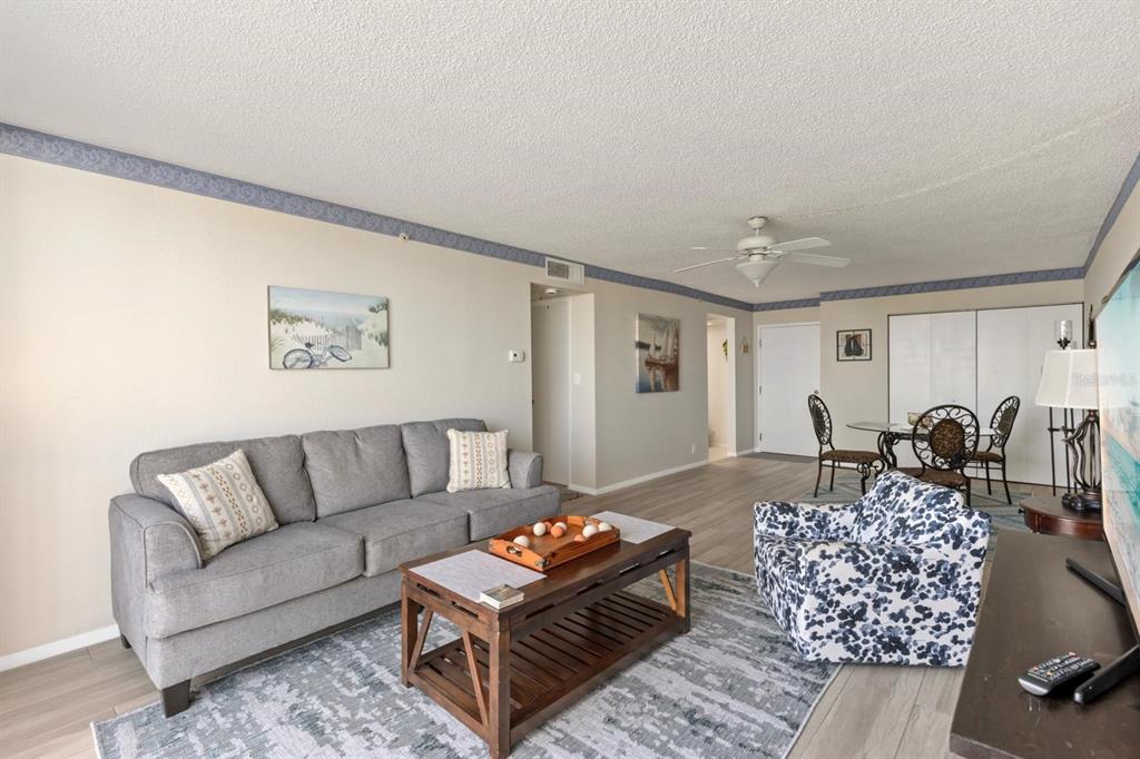 255 Dolphin Point, Unit 513 Clearwater Beach, FL 33767 - Photo 8 of 18 a living room with furniture and wooden floor