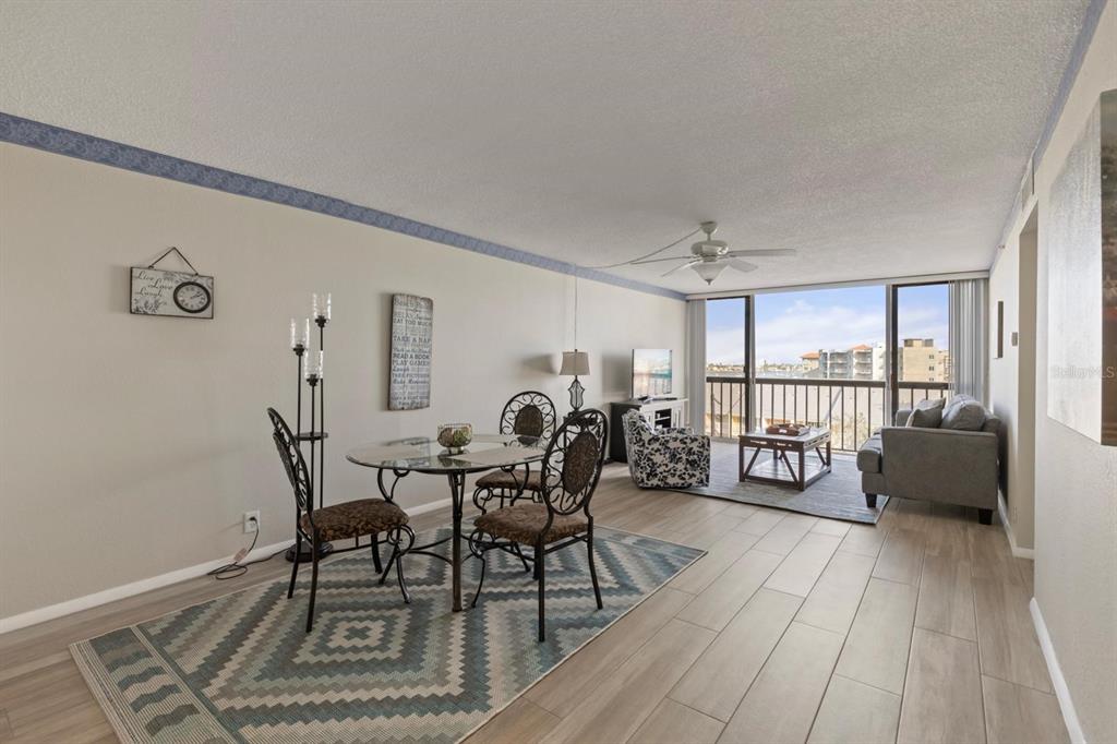 255 Dolphin Point, Unit 513 Clearwater Beach, FL 33767 - Photo 10 of 18 a view of a dining room with furniture and wooden floor