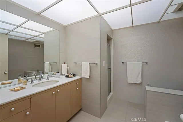 a spacious bathroom with a granite countertop sink and a mirror