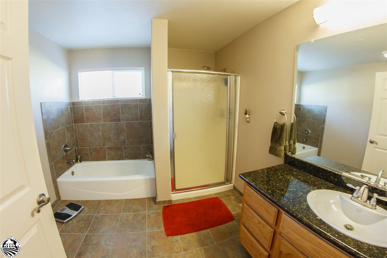 2112 Quail Hill Road Copperopolis, CA 95228 - Photo 18 of 22 a bathroom with a granite countertop sink a mirror and a bathtub