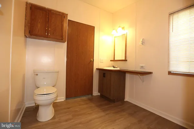 a bathroom with a sink toilet and window