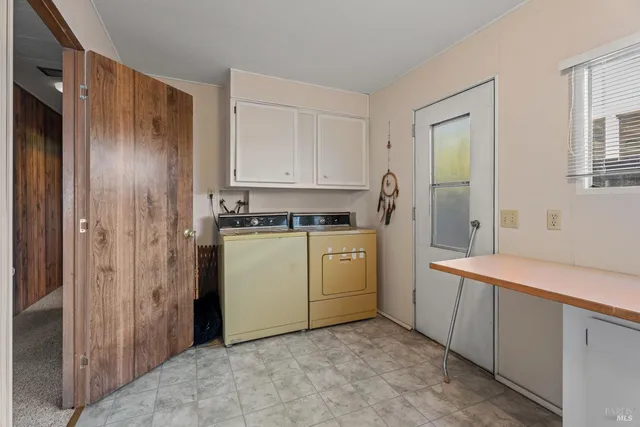 a utility room with cabinets washer and dryer