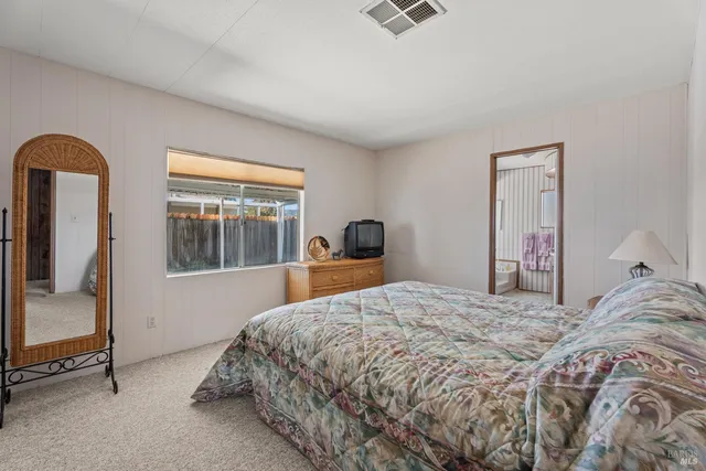 a bedroom with a bed and a mirror