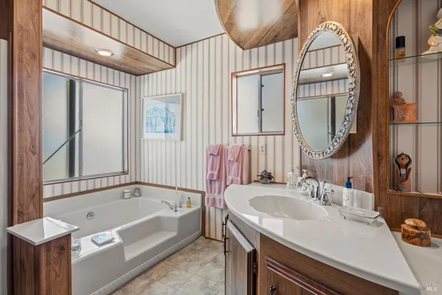 a bathroom with a tub sink and mirror
