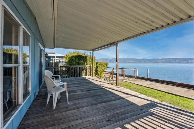 a view of a chairs and table on the wooden deck