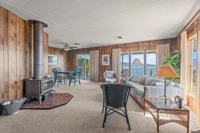 a living room with furniture a large window and wooden floor