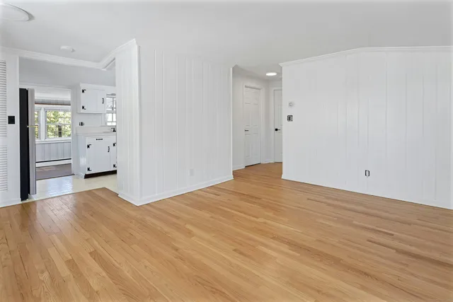 a view of empty room with wooden floor