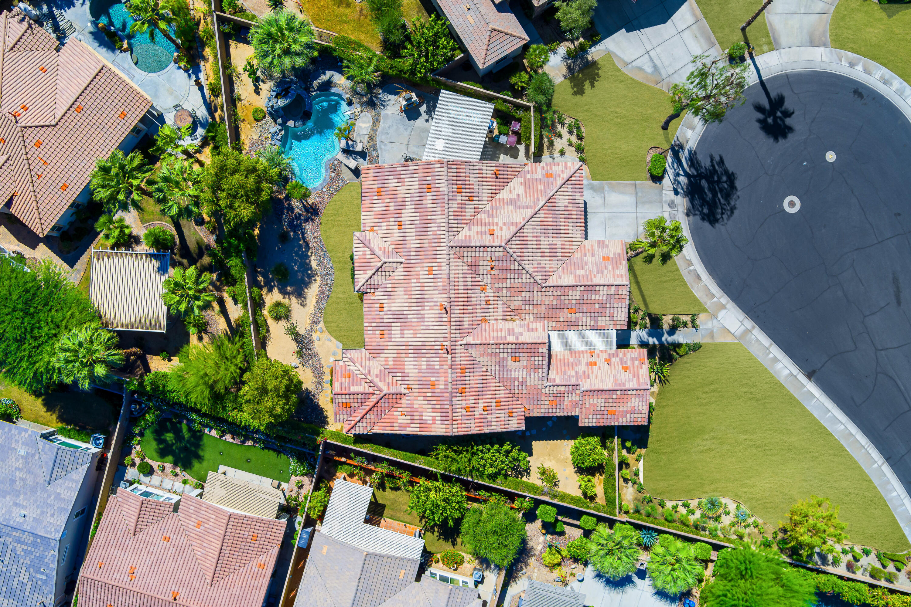 an aerial view of a house with a yard and tennis court
