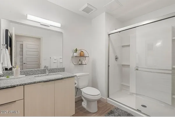 a bathroom with a granite countertop sink toilet and shower
