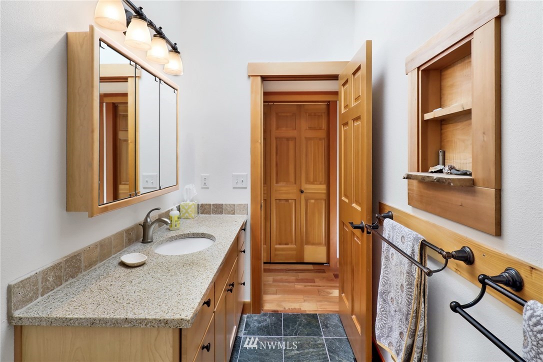 4760 Mission Road Bellingham, WA 98226 - Photo 25 of 40 a bathroom with a granite countertop sink and a mirror