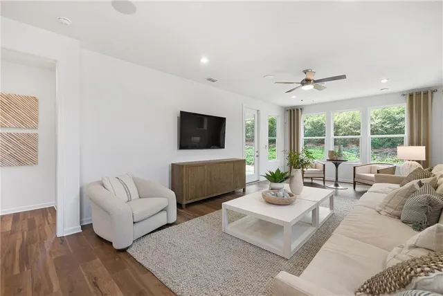 a living room with furniture and view of kitchen