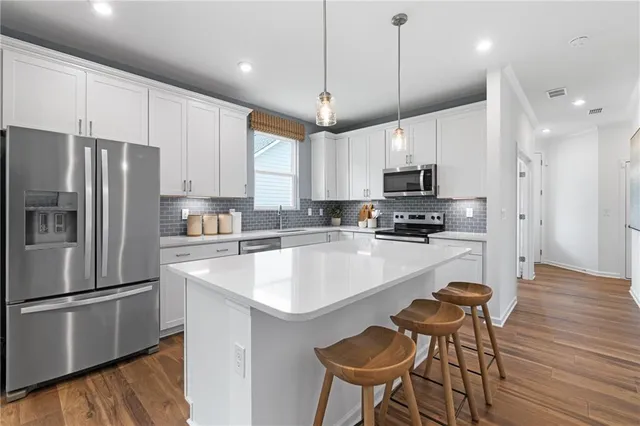 a kitchen with a sink a counter space appliances and wooden floor
