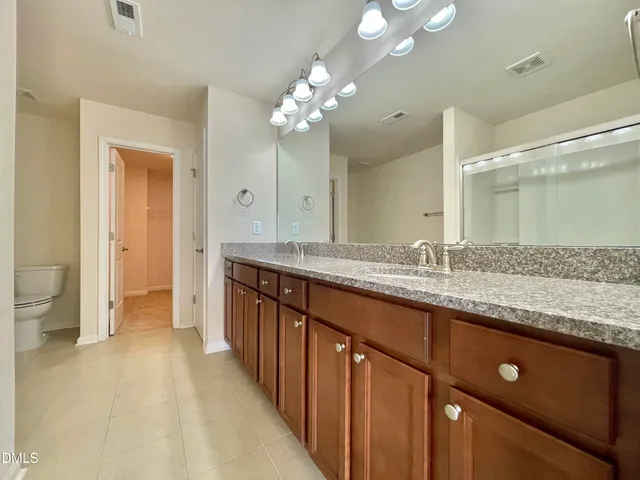 a bathroom with a granite countertop shower a mirror and a sink