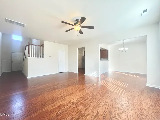 a view of a livingroom with wooden floor and a ceiling fan