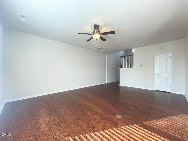 a view of a big room with wooden floor and a ceiling fan