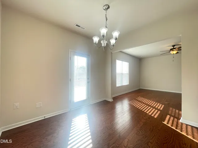 a view of a room with a ceiling fan and wooden floor