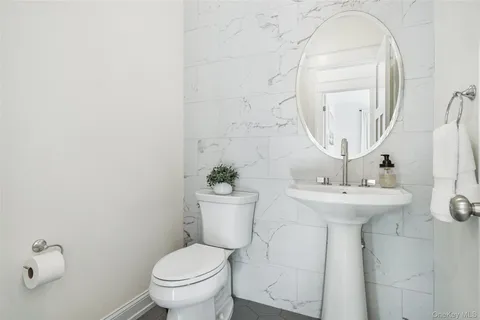 a bathroom with a sink a toilet and a mirror