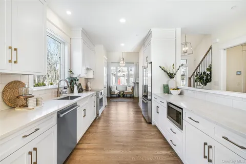a large kitchen with stainless steel appliances sink a stove and cabinets