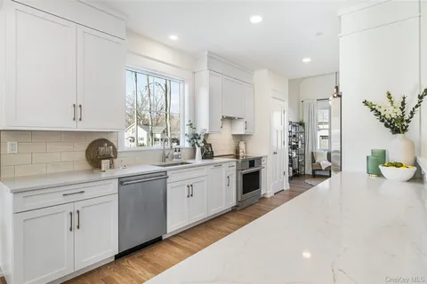 a kitchen with white cabinets and appliances