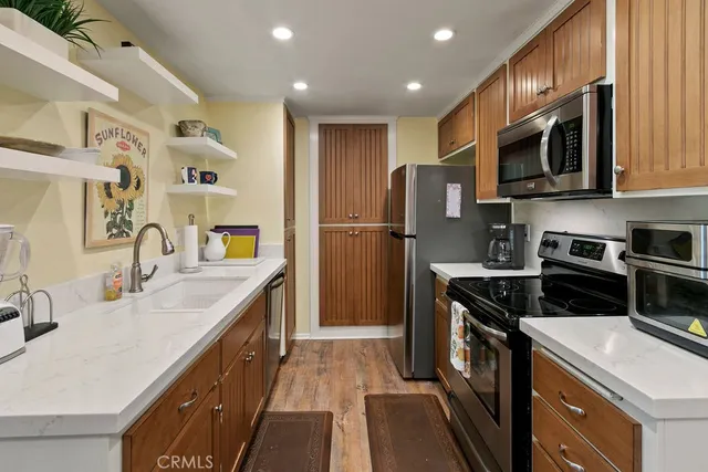 a kitchen with stainless steel appliances granite countertop a sink stove and refrigerator
