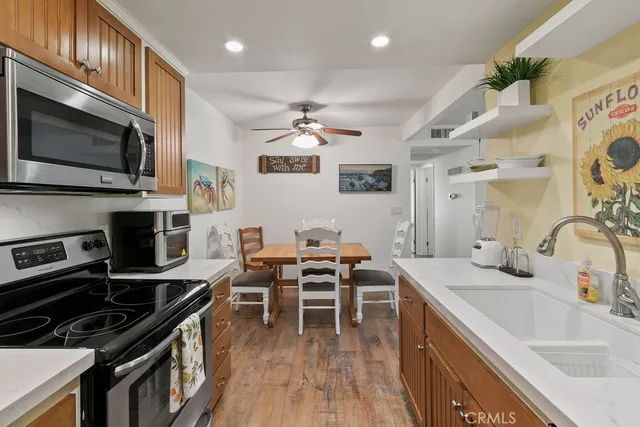 a kitchen with stainless steel appliances a stove a sink a microwave and a refrigerator