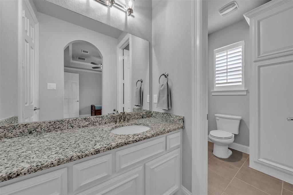 1060 Waters Edge Court Oak Point, TX 75068 - Photo 11 of 40 a bathroom with a granite countertop sink toilet and mirror