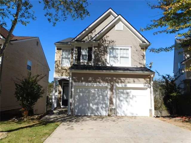 a view of a house with a small yard and potted plants