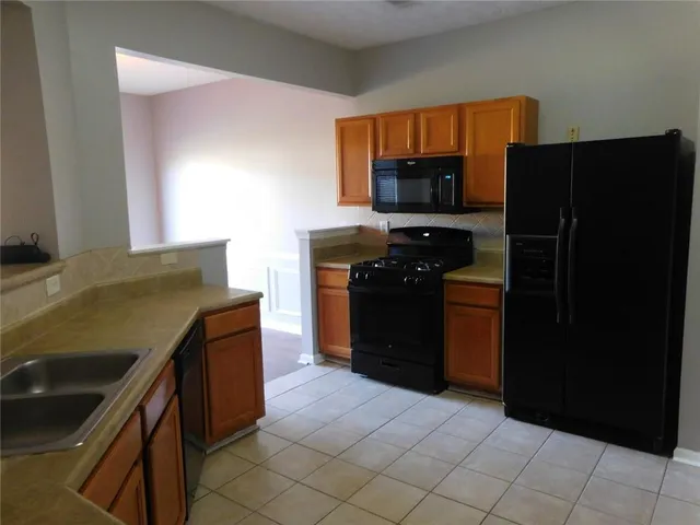 a kitchen with stainless steel appliances granite countertop a refrigerator and a stove
