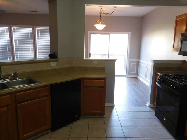 a kitchen with a sink a stove and cabinets