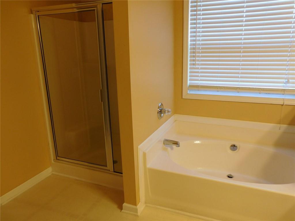 566 Pond Lillies Road Southeast Lawrenceville, GA 30045 - Photo 23 of 45 a bathroom with a tub and shower
