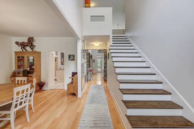 a view of a hallway with wooden floor and staircase