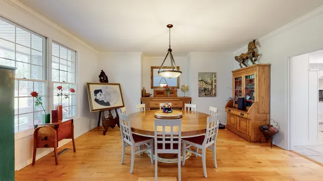 a dining room with furniture window and wooden floor