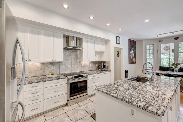 a kitchen with kitchen island granite countertop a sink stove and refrigerator