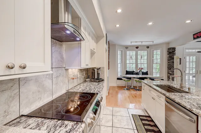 a kitchen with stainless steel appliances granite countertop a sink stove and cabinets