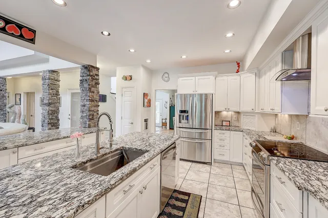 a kitchen with stainless steel appliances granite countertop a sink stove and refrigerator