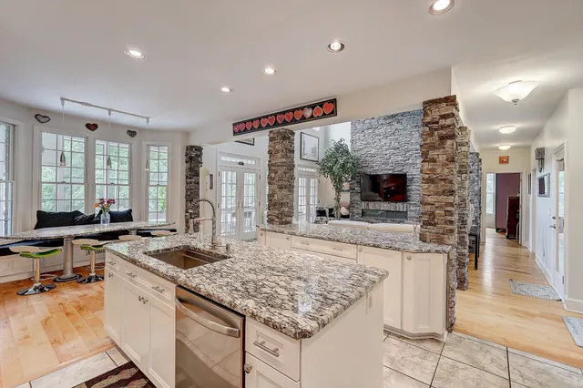 a kitchen with stainless steel appliances granite countertop sink stove top oven and cabinets