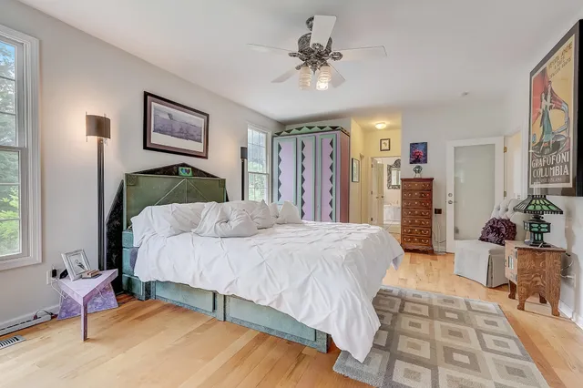 a spacious bedroom with a bed a chandelier and mirror