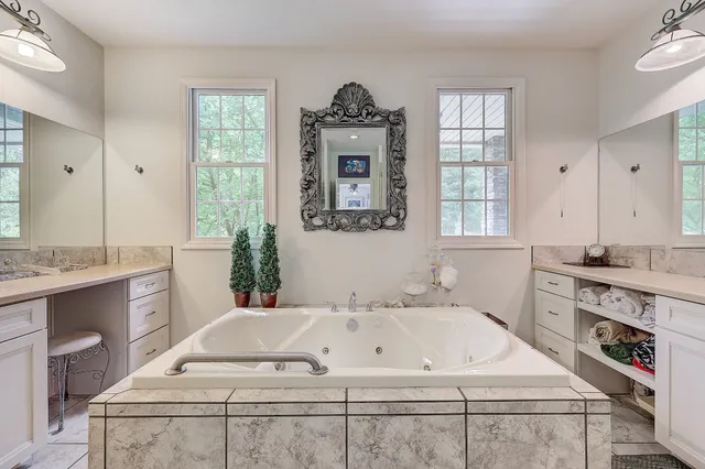 a bathroom with a tub sink and mirror