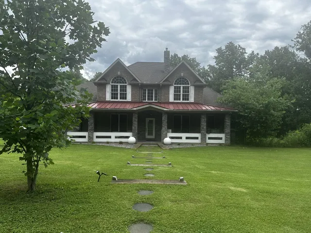 a front view of house with yard and trees